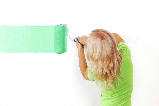 woman paints the wall brush