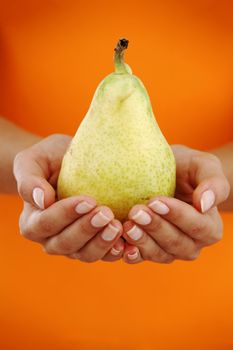 pear in woman hands close up