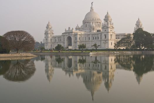 Victoria Memorial reflected in an ornamental lake at dusk. Kolkata, India