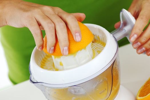 woman squeezes juice by juicer