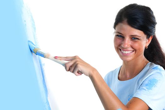 woman paints the wall brush