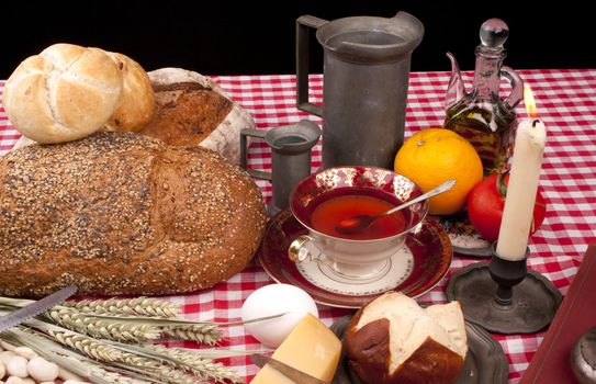 Old fashioned lunch wtih bread and buns on a table against a black background