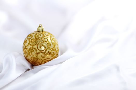  gold christmas ball on white silk