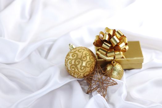  gold christmas ball on white silk