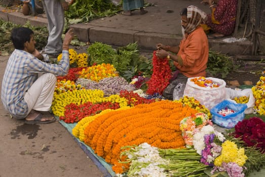 Man selling flowers and garlands on a city street in Kolkata (Calcutta), West Bengal, India