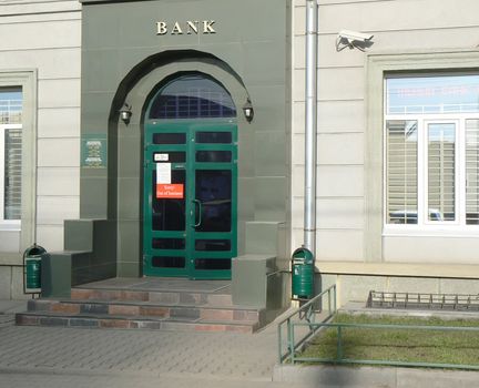 Front porch of bank with "Out of buisness" announcement