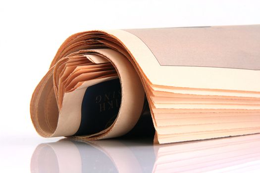 newspaper rolled with reflection isolated on white background media and publications