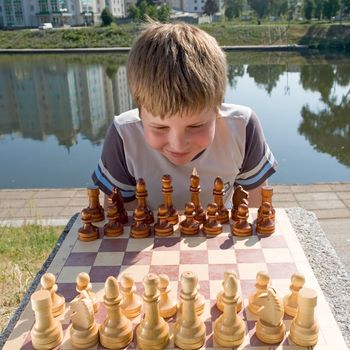 A little boy chess with river at background