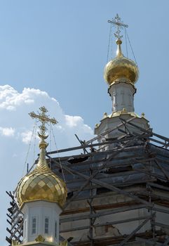 crosses on the cupolas of orthodox temple with sky at background