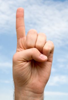one. hand gesture with blue sky at background