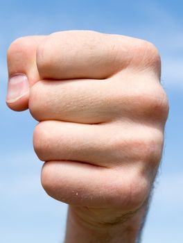 fist. hand gesture with blue sky at background