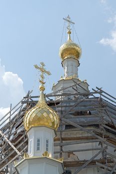 crosses on the cupolas of orthodox temple with sky at background