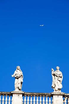 White classical statue of St. Peter's Basilica in Vatican and flying air in blue sky, Rome, Italy