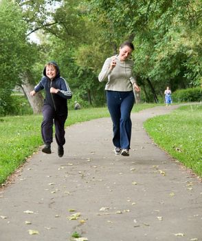 woman and boy run along the road