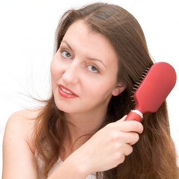 beautiful girl combs hair on a white background