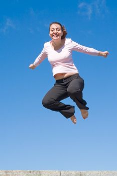 the girl jumps with sky at background