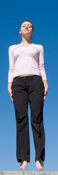 the girl jumps with sky at background