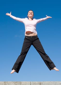 the girl jumps with sky at background