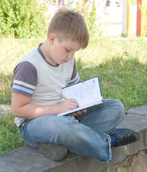 The little boy writes to writing-books