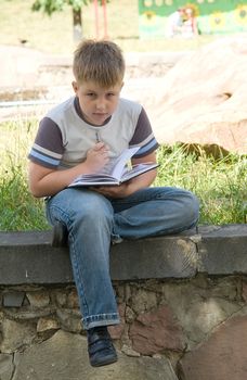 The little boy writes to writing-books