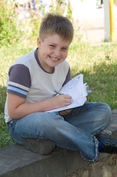 The little boy writes to writing-books