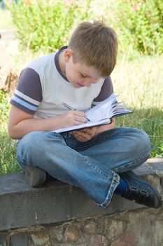 The little boy writes to writing-books