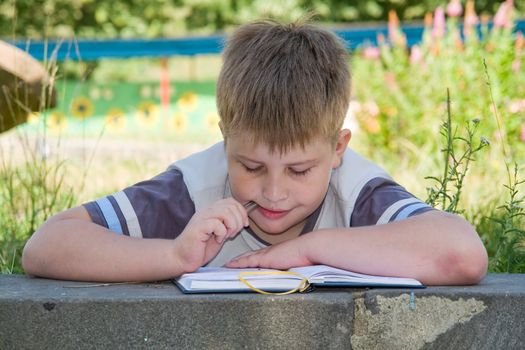 The little boy writes to writing-books