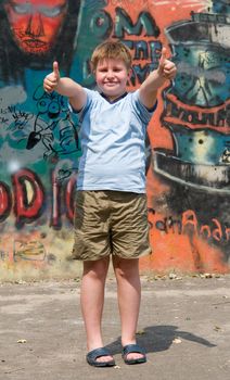 A smiling child with graffiti at background