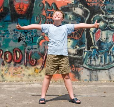 A smiling child with graffiti at background