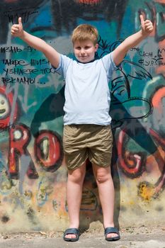 A smiling child with graffiti at background