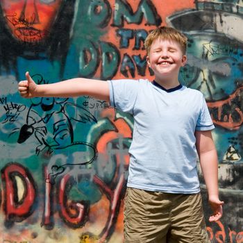 A smiling child with graffiti at background