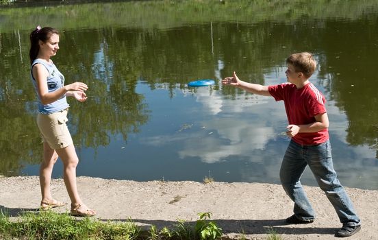 Mom and son playing frisbee with sky at background