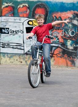 boy on a bicycle with graffiti at background