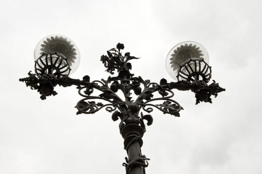 Lamp with a metal stand and glass enclosure. Construction detail of the park.