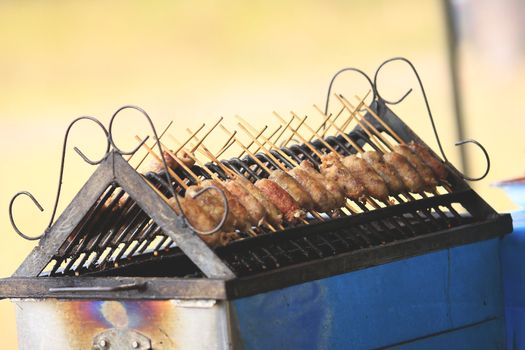 Grilled sausage over a hot barbecue grill.