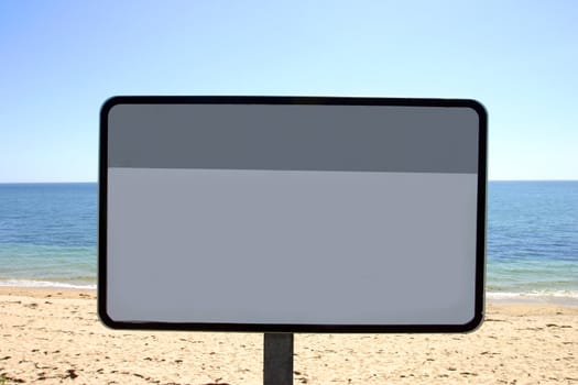 Blank beach sign on French beach with a blue sky