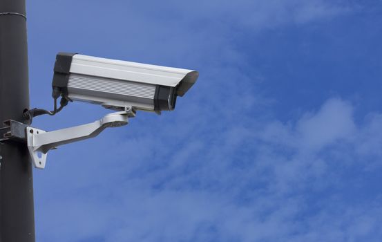 Security / surveillance camera against a clear blue sky