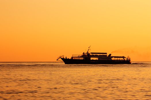 Silhouette of cruise ship at sunset in a sea