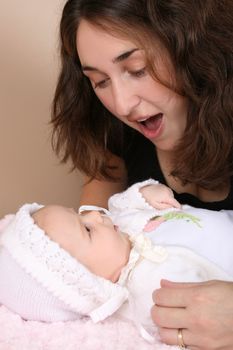 Beautiful brunette mother looking at her two month old baby girl 