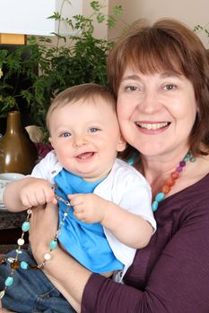 Beautiful baby boy sitting by his grandmother