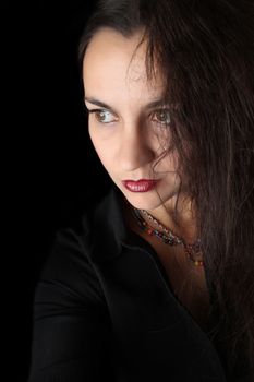 Dramatic brunette female against black background wearing black