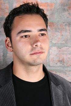 Male model against a rough brick wall background 