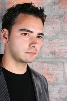 Male model against a rough brick wall background 