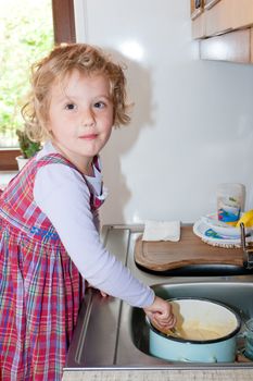 Little granddaughter helping grandma in a kitchen