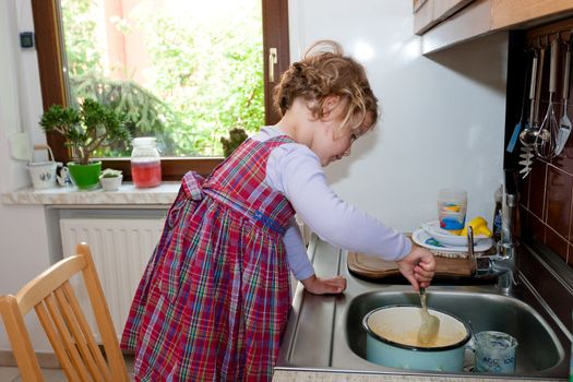 Little granddaughter helping grandma in a kitchen