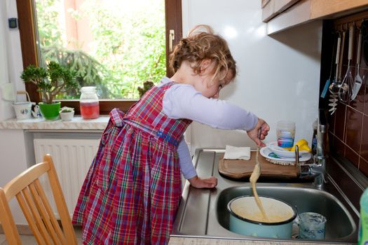 Little granddaughter helping grandma in a kitchen