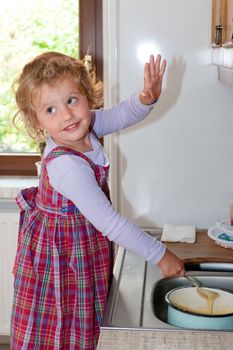 Little granddaughter helping grandma in a kitchen