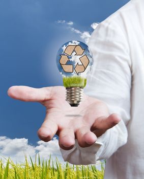 paddle , windmill and blue sky in light bulb on hand