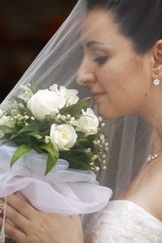 The beautiful bride is closed by a veil