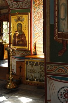 Interior of russian orthodox church. Candles under the ancient icon framed with the gold.